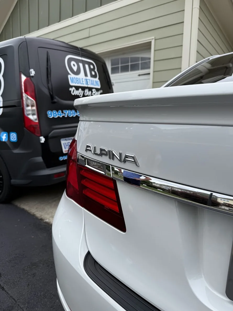 White BMW Alpina after detailing, next to the OTB van
